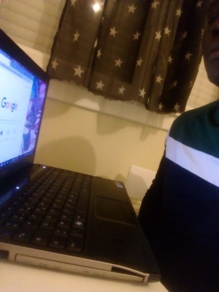 Un jeune homme regarde un ordinateur portable ouvert en fonctionnement